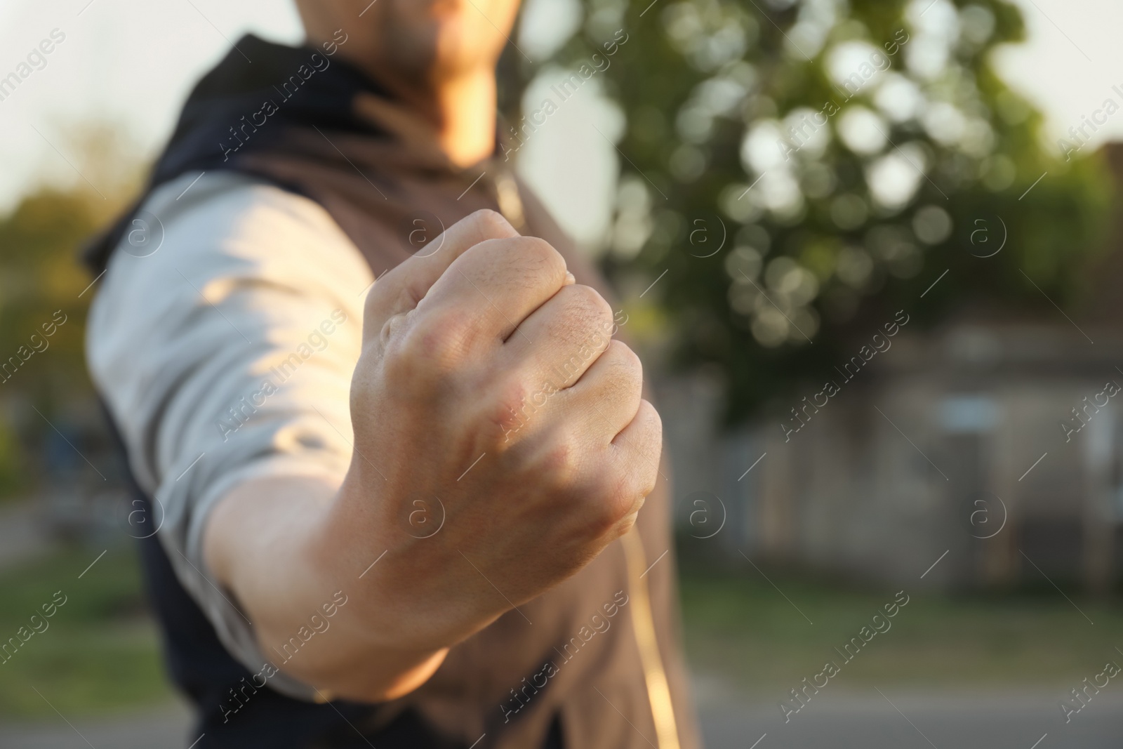 Photo of Angry man with clenched fist outdoors, closeup