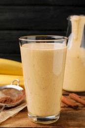 Photo of Tasty banana smoothie and ingredients on wooden table