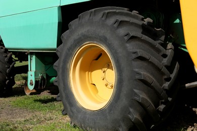 Photo of Modern combine harvester wheel outdoors, closeup view