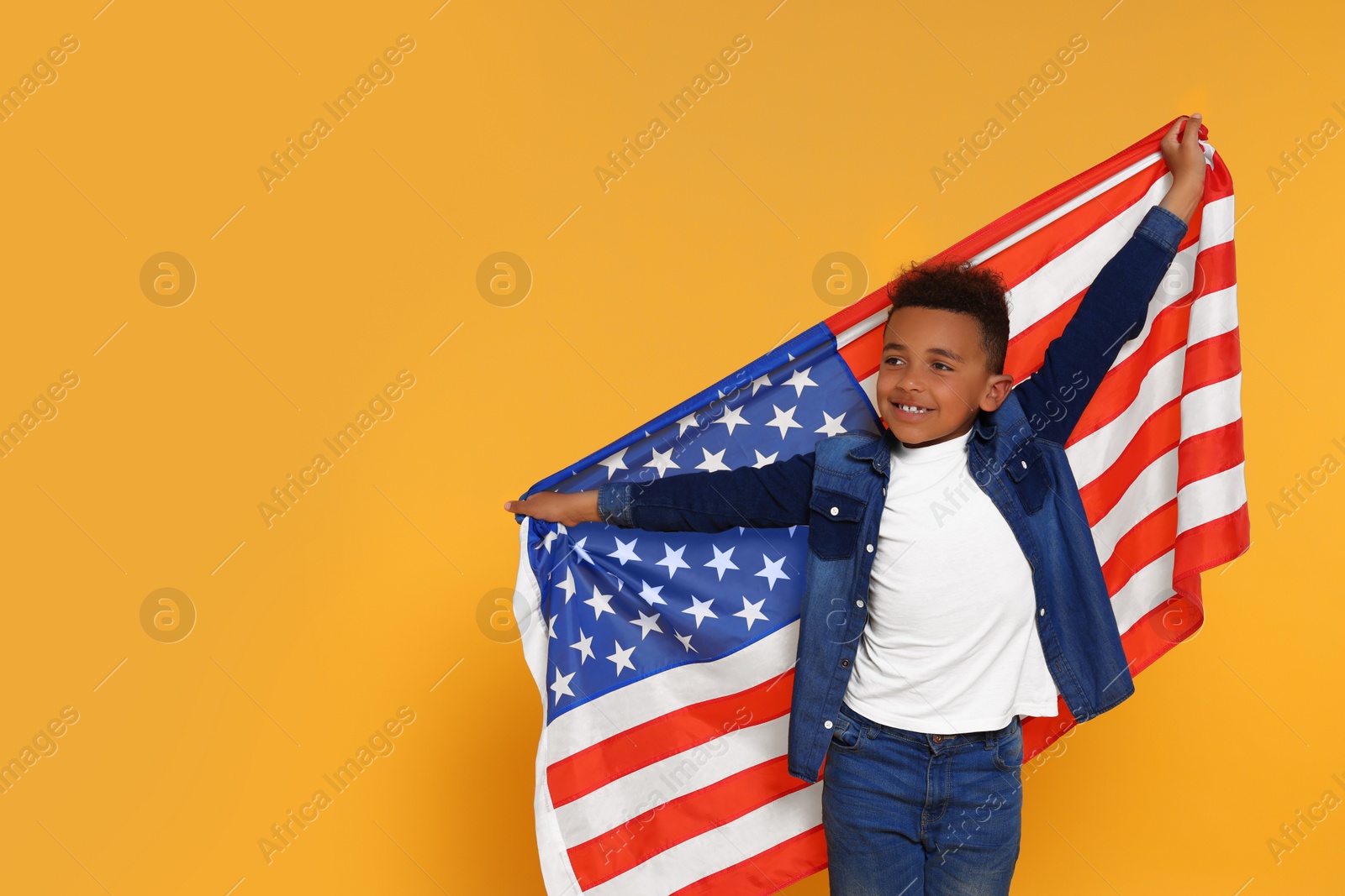 Photo of 4th of July - Independence Day of USA. Happy boy with American flag on yellow background, space for text