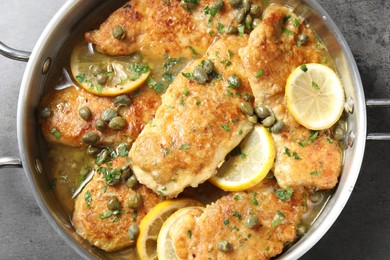 Photo of Delicious chicken piccata on grey table, top view