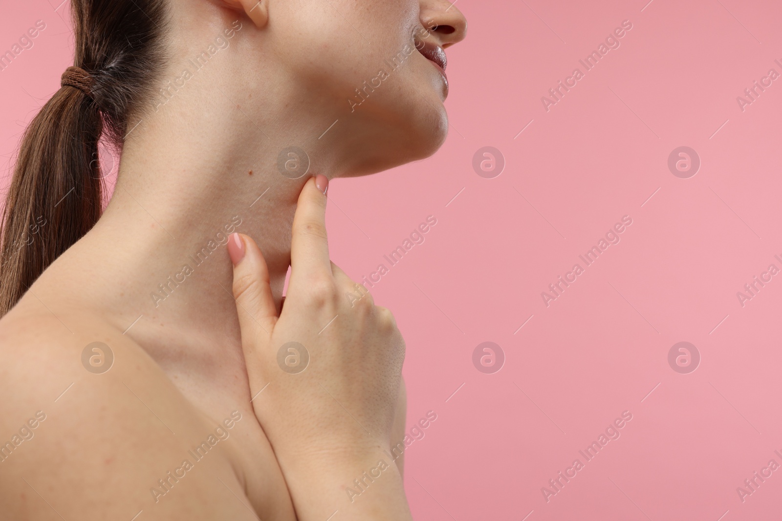 Photo of Woman touching her neck on pink background, closeup. Space for text