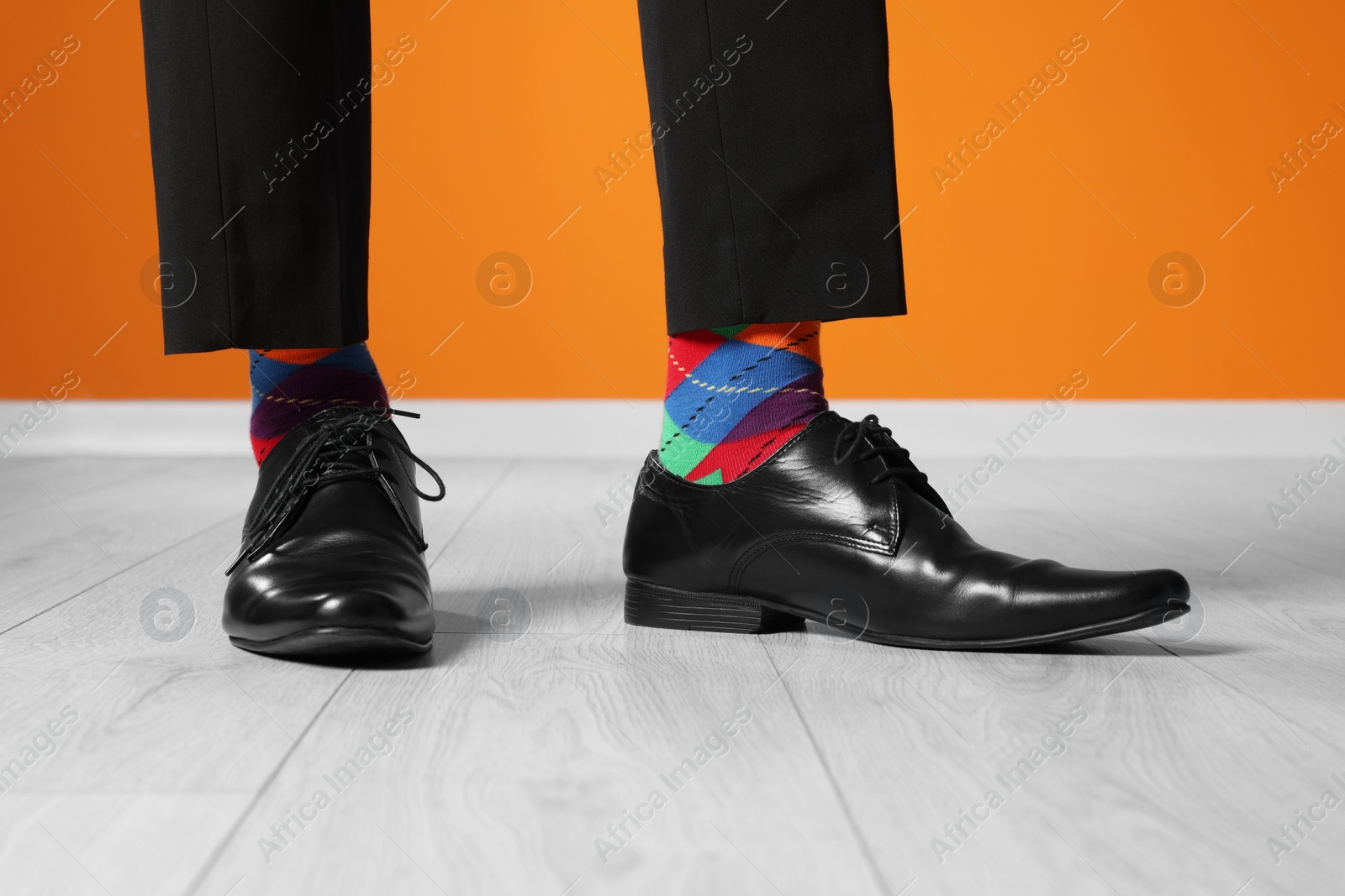 Photo of Man wearing stylish shoes and colorful socks indoors, closeup