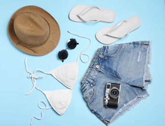 Flat lay composition with stylish beach accessories on light blue background