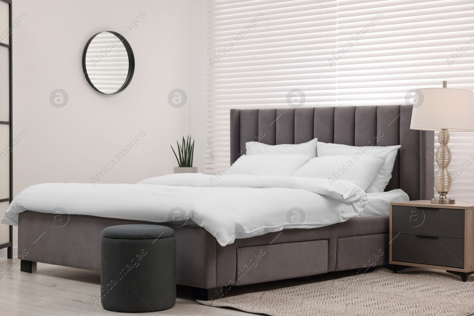 Photo of Stylish bedroom interior with large bed and lamp