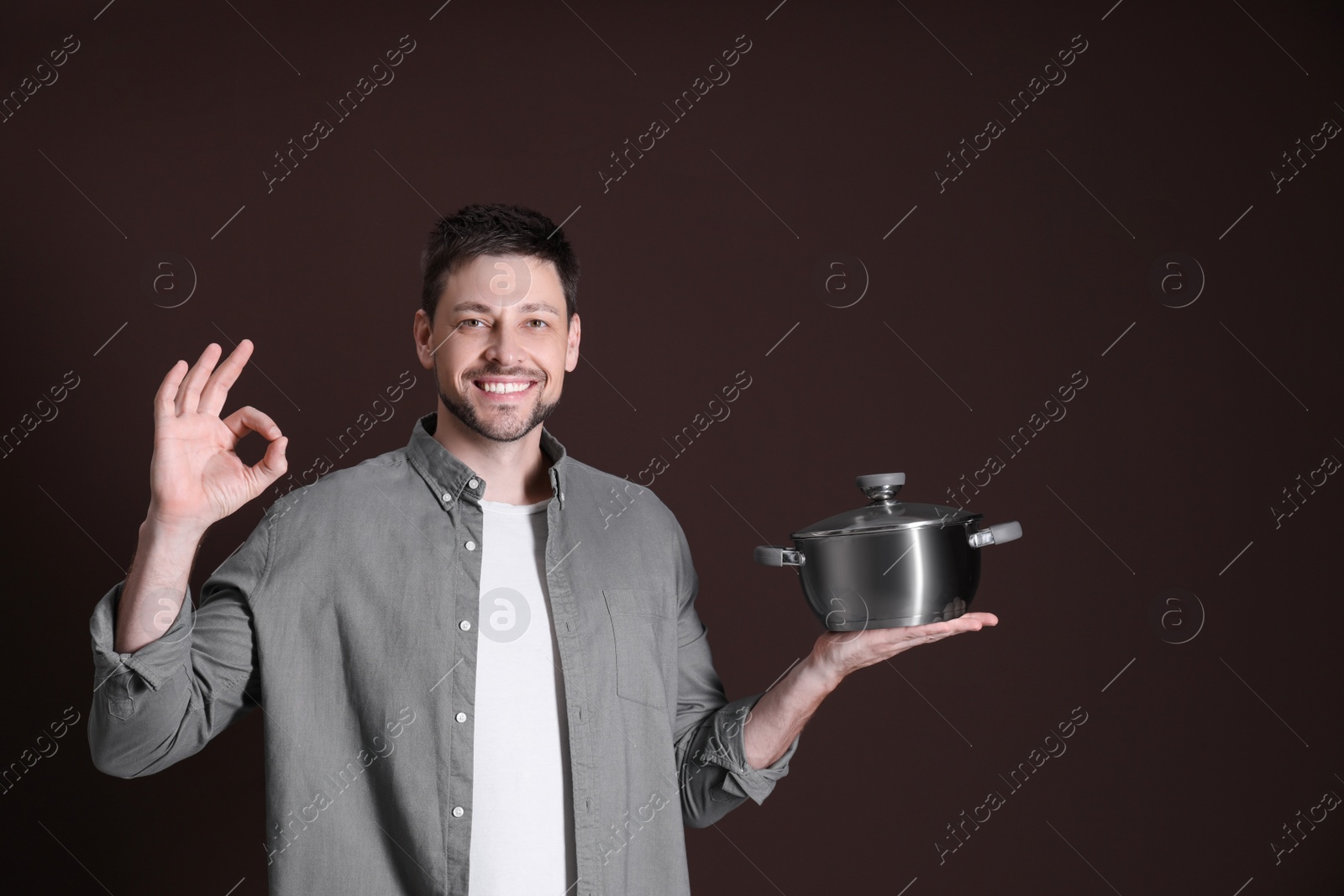 Photo of Happy man with pot on dark background