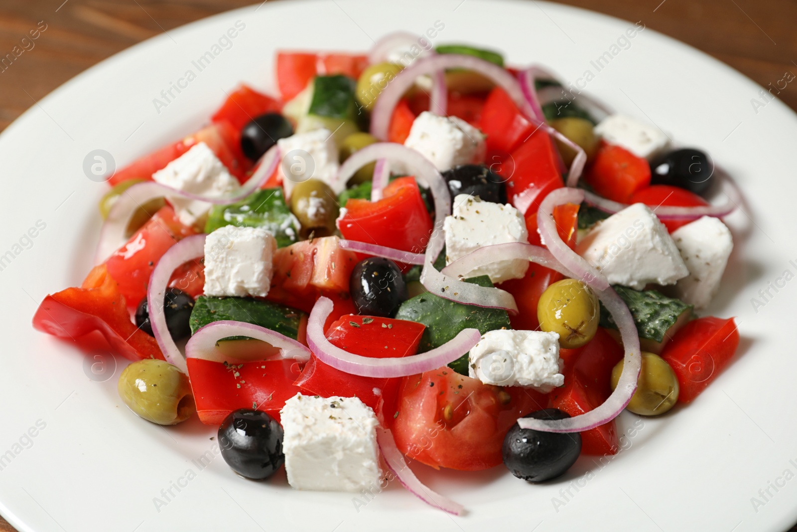 Photo of Fresh salad with delicious cheese and olives on plate, closeup