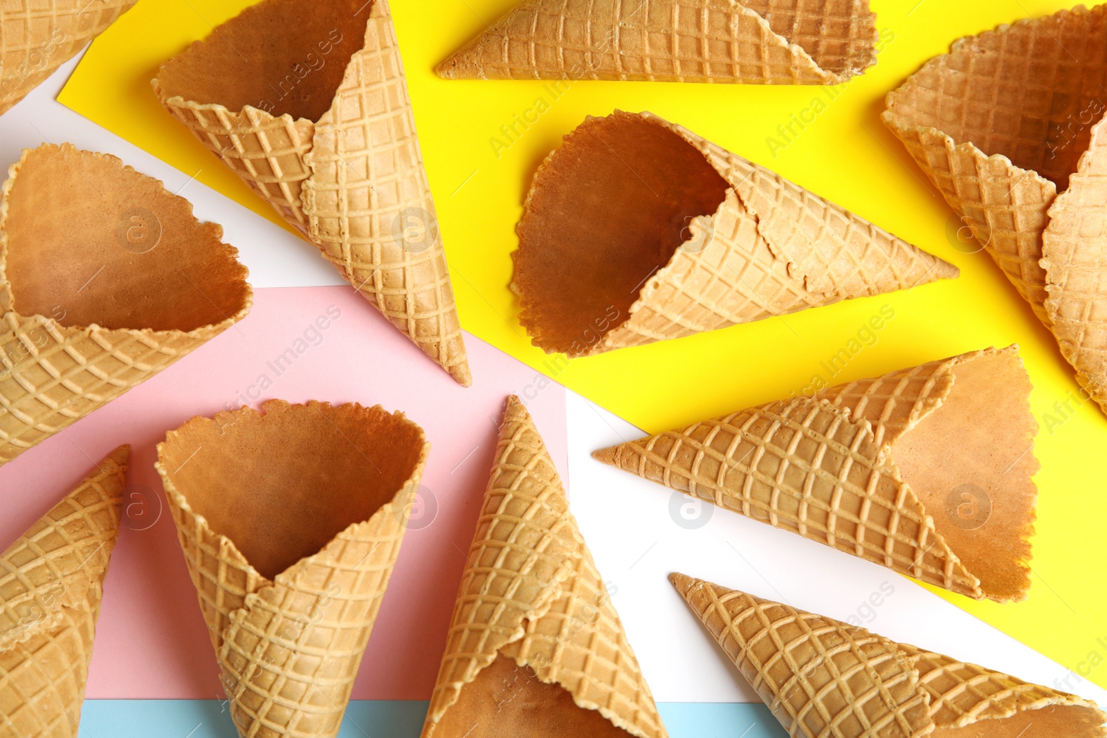 Photo of Empty wafer ice cream cones on color background, flat lay