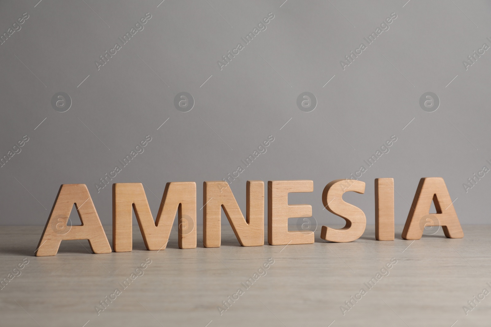 Photo of Word Amnesia made of wooden letters on white table