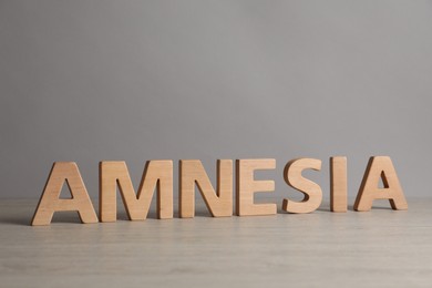 Photo of Word Amnesia made of wooden letters on white table