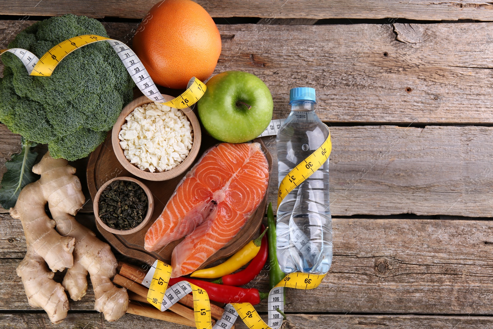 Photo of Metabolism. Different food products and measuring tape on wooden table, flat lay with space for text