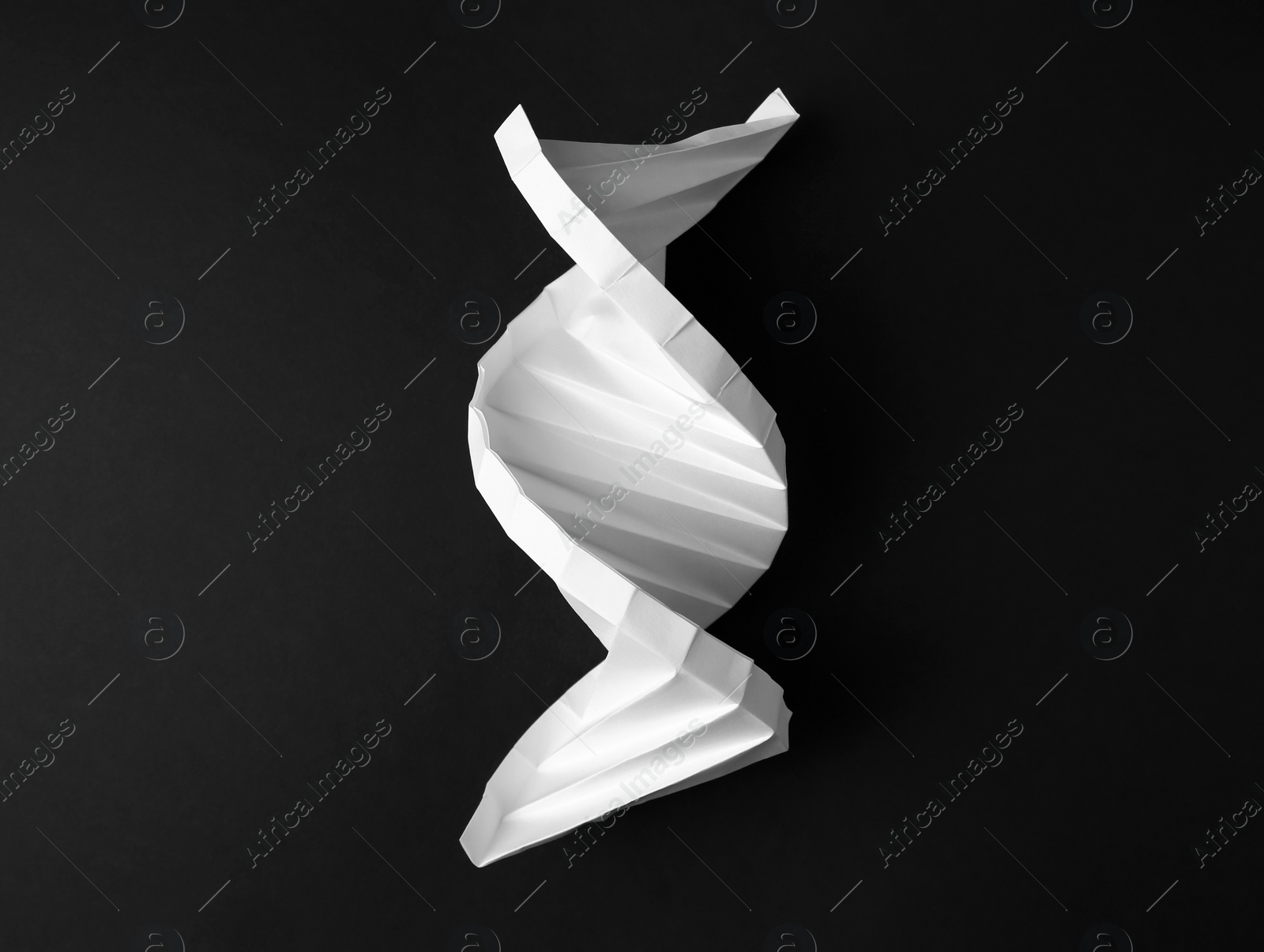 Photo of Paper model of DNA molecular chain on black background, top view