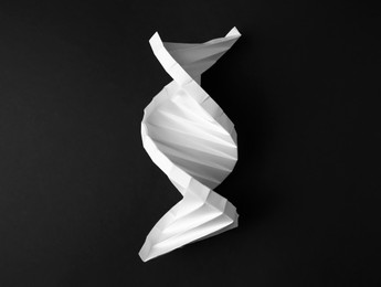 Photo of Paper modelDNA molecular chain on black background, top view