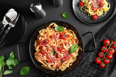 Flat lay composition with tasty pasta on black table