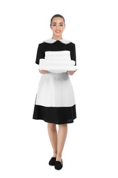 Young chambermaid with stack of clean towels on white background