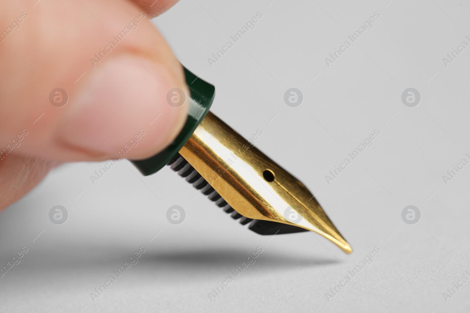 Photo of Woman with fountain pen above white paper, closeup