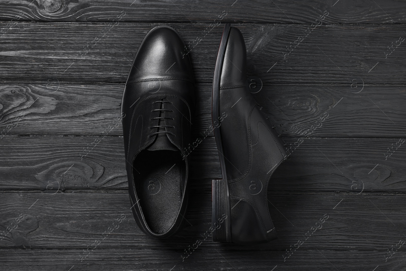 Photo of Pair of leather men shoes on black wooden background, top view