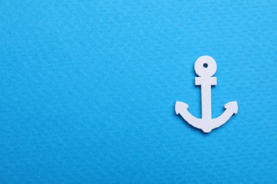 Photo of Anchor figure on light blue background, top view. Space for text
