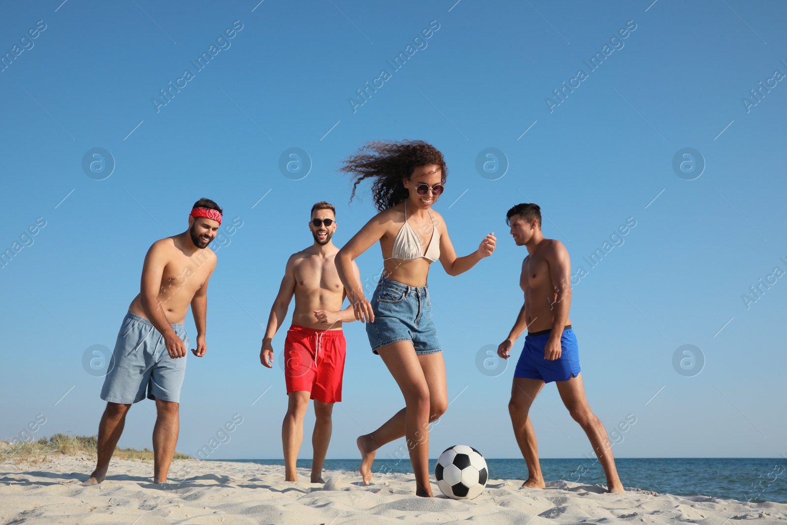 Photo of Group of friends playing football on beach