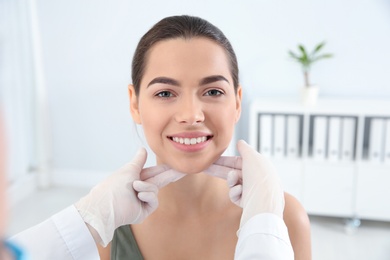 Photo of Dermatologist examining patient's face in clinic. Skin cancer checkup