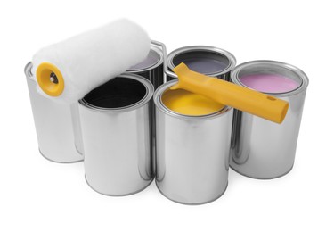 Cans with different paints and roller on white background