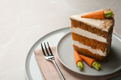 Photo of Piece of sweet carrot cake with delicious cream on light table, space for text