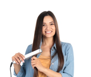 Young woman using hair iron on white background