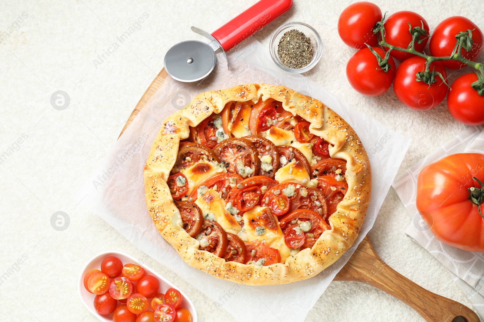 Photo of Flat lay composition of tasty galette with tomato and cheese (Caprese galette) on light textured table