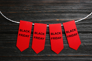 Word SALE made with red tags on dark wooden background, flat lay. Black Friday concept