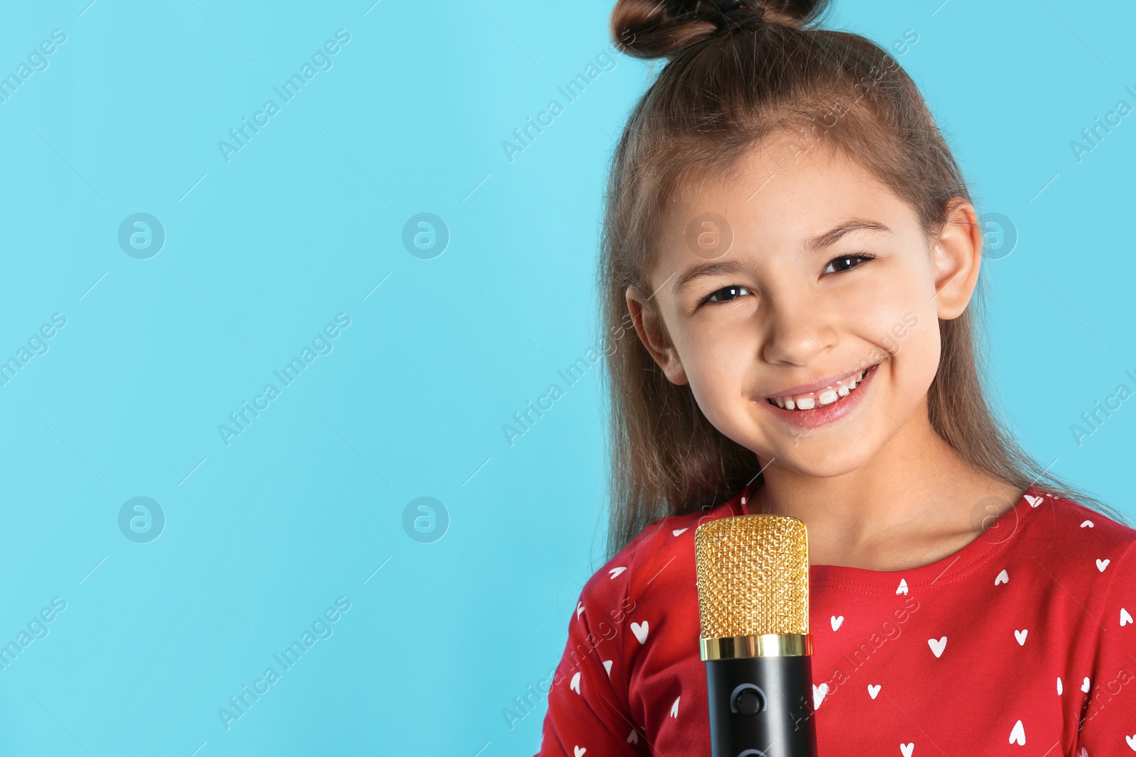 Photo of Cute funny girl with microphone on color background. Space for text