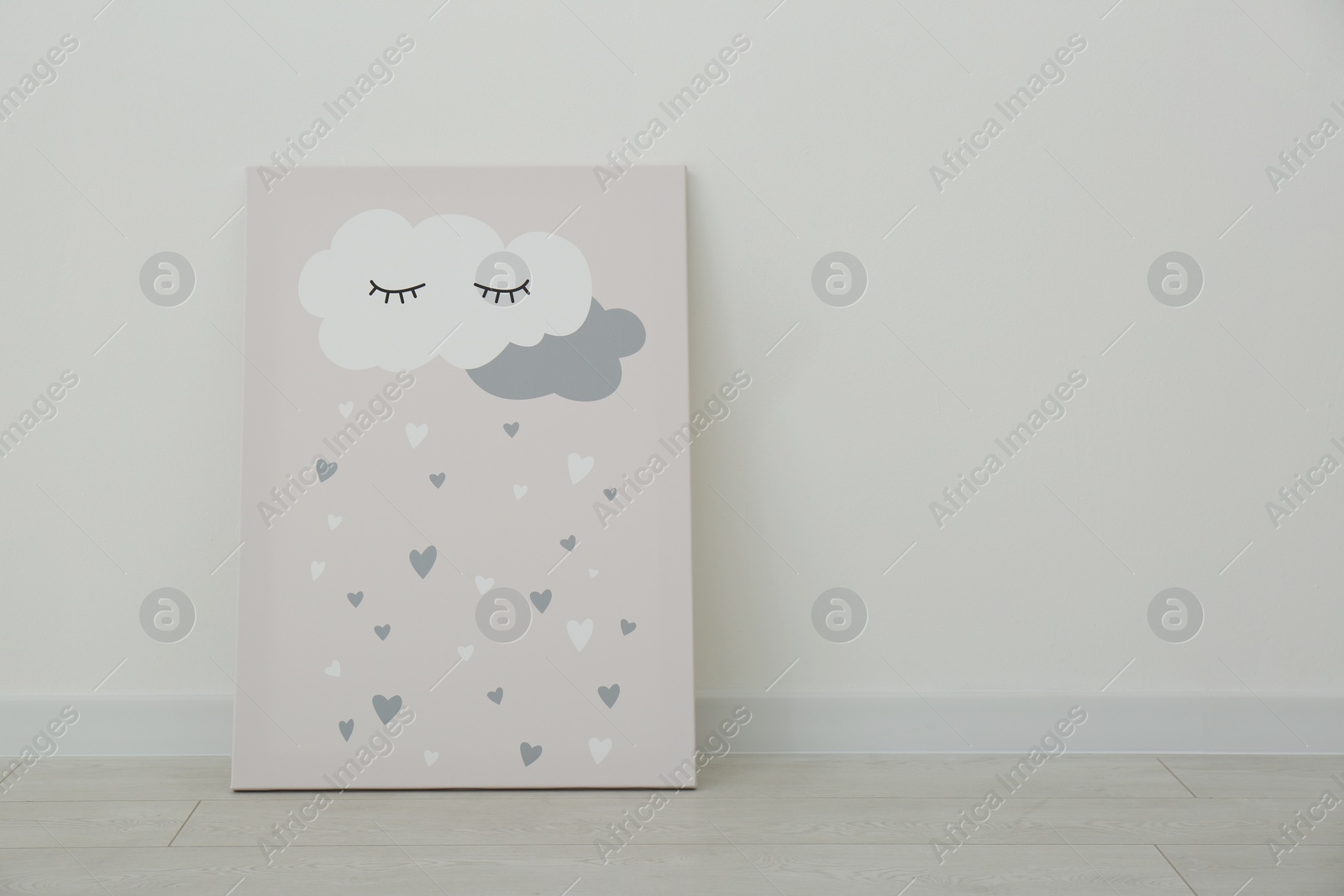 Photo of Adorable picture of cloud and hearts on floor near white wall, space for text. Children's room interior element