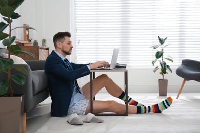 Businessman in underwear pretending to wear formal clothes during video call at home