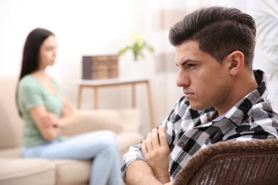 Photo of Unhappy man after quarrel with his girlfriend indoors. Relationship problems