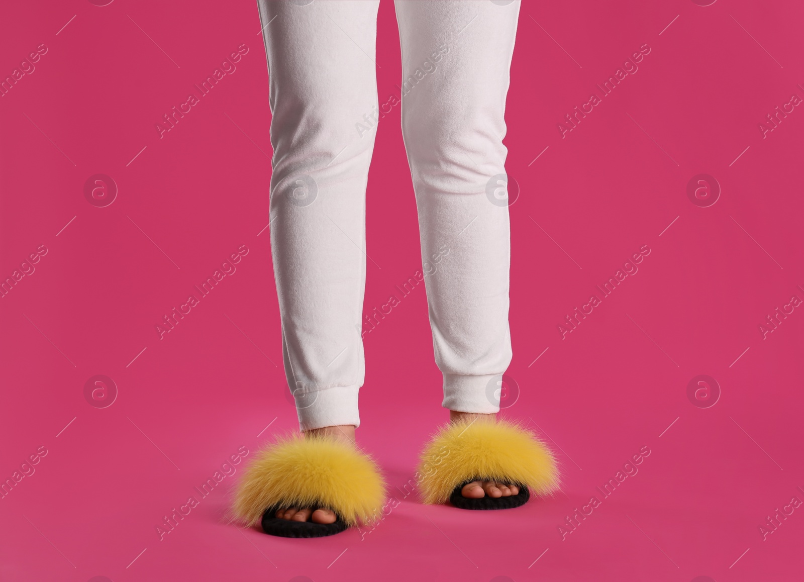 Photo of Woman in fluffy slippers on pink background, closeup