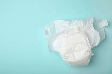 Photo of Baby diaper on turquoise background, top view. Space for text