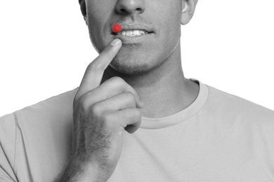 Man with herpes touching lips against white background, closeup. Black and white effect