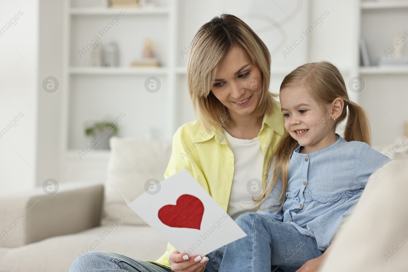 Photo of Little daughter congratulating her mom with greeting card at home, space for text. Happy Mother's Day