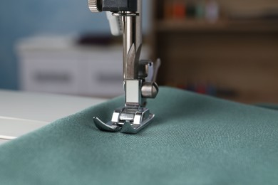 Photo of Sewing machine with color fabric indoors, closeup