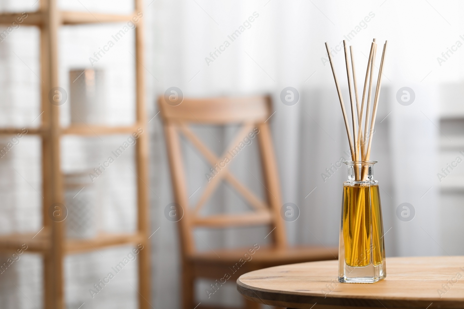 Photo of Reed air freshener on wooden table indoors, space for text