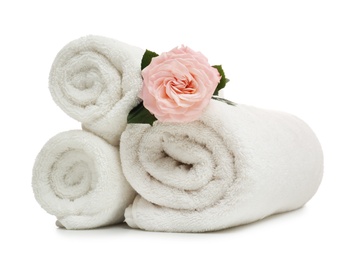 Clean rolled towels with flower on white background