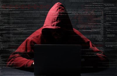 Image of Cyber attack. Anonymous hacker working with laptop on black background. Different digital codes and icons around him