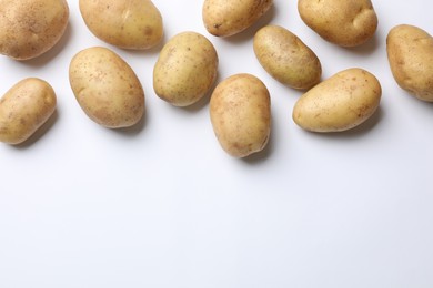 Photo of Fresh raw potatoes on white background, flat lay. Space for text