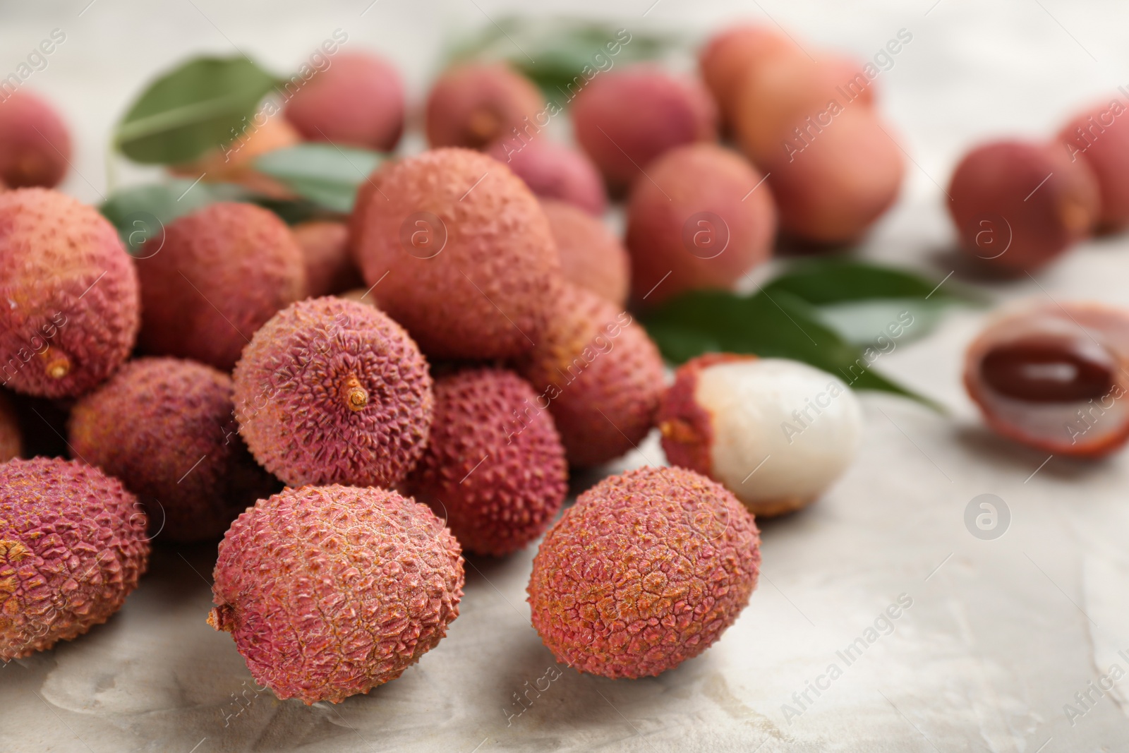 Photo of Fresh ripe lychee fruits on light grey table