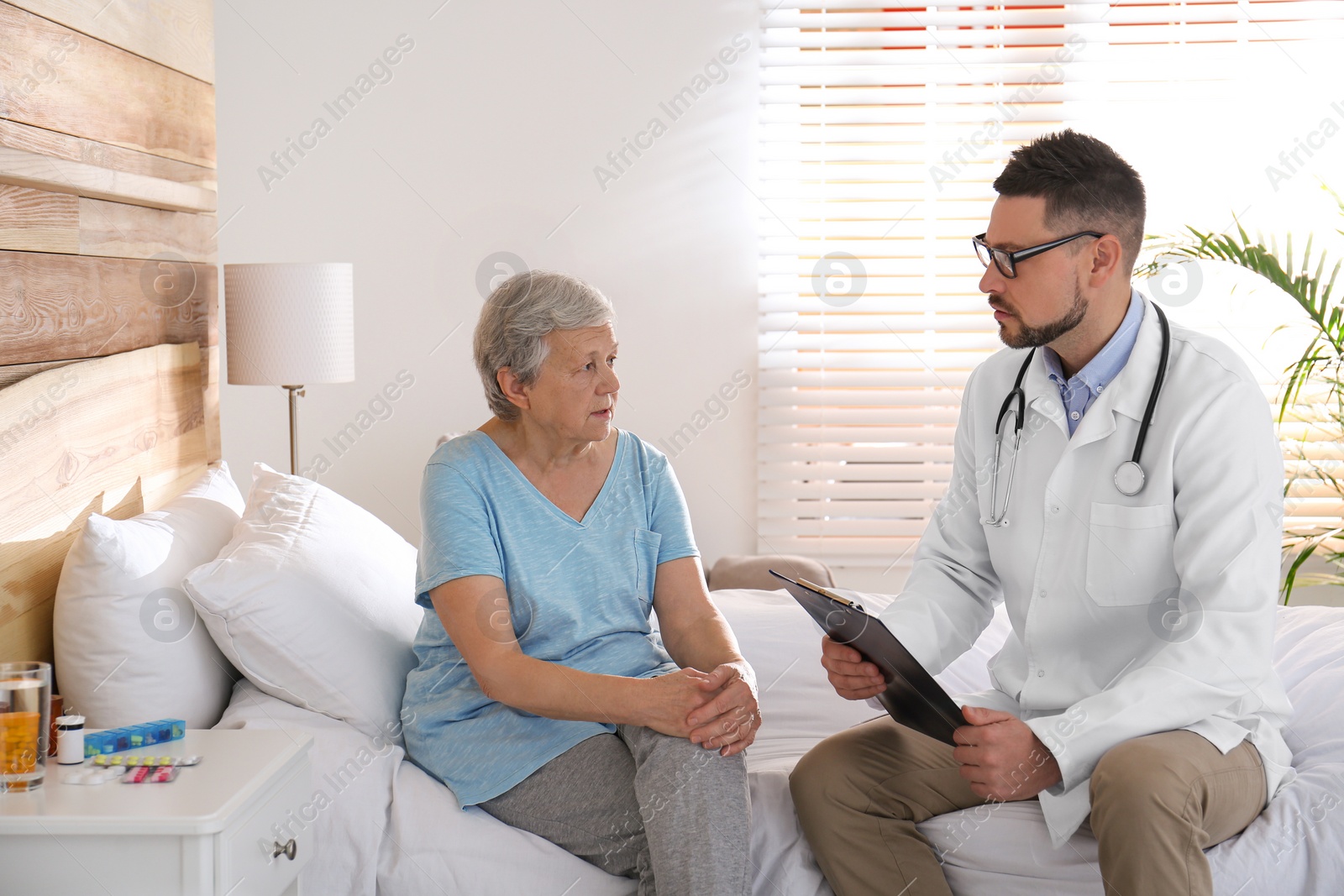 Photo of Doctor examining senior patient in modern hospital