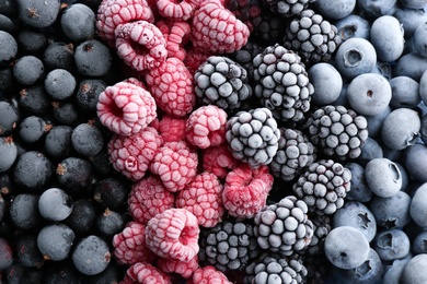 Photo of Mix of different frozen berries as background, top view