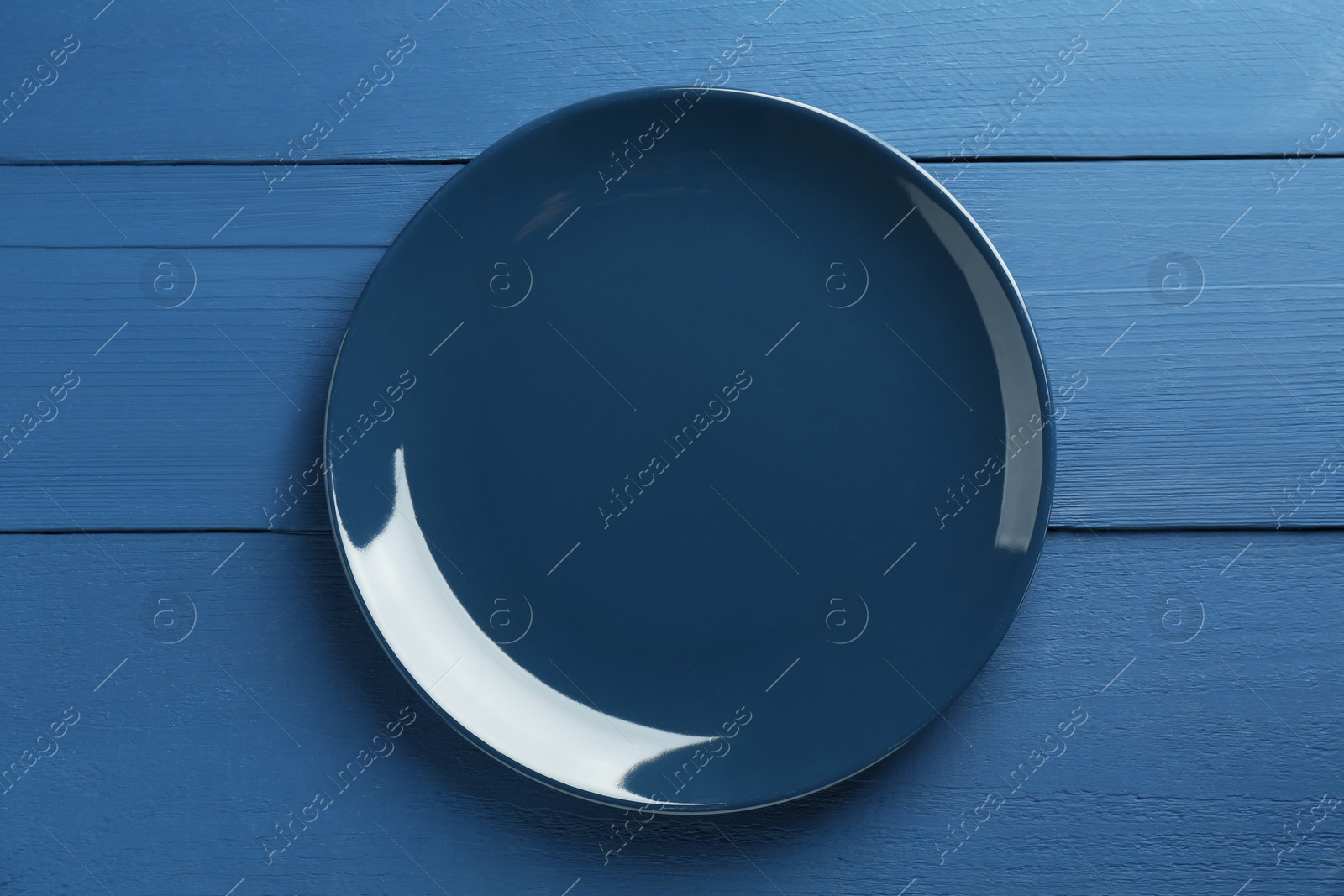 Photo of Beautiful ceramic plate on blue wooden table, top view
