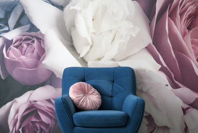 Photo of Comfortable armchair near wall with floral wallpaper. Stylish living room interior