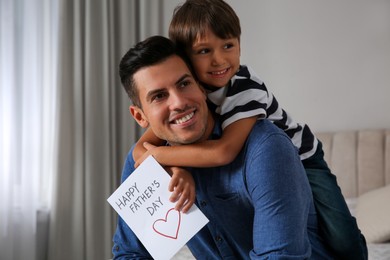 Photo of Little boy greeting his dad with Father's Day at home