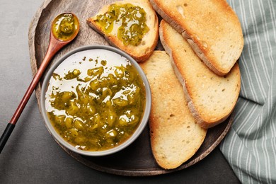 Photo of Toasts with delicious gooseberry jam on grey table, top view