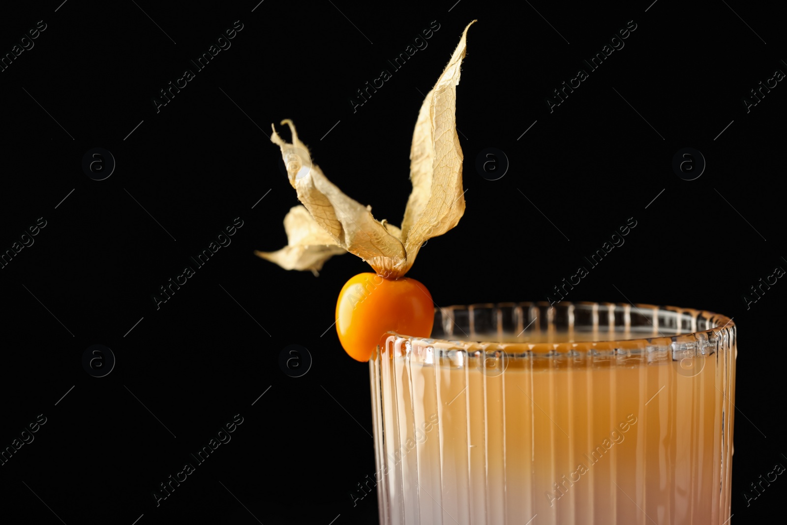 Photo of Tasty cocktail decorated with physalis fruit on black background, closeup